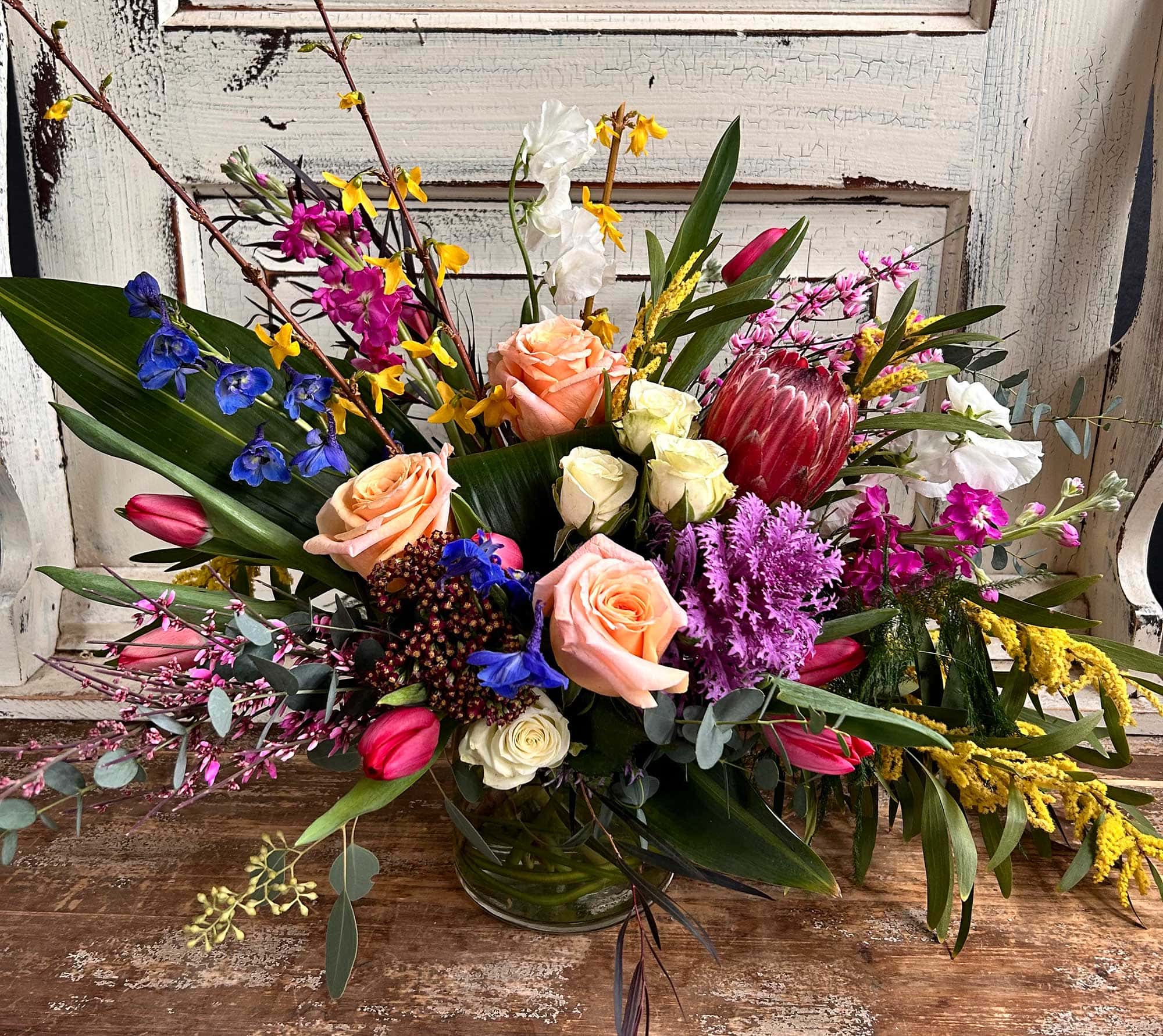 A bright arrangement in reds, purples, pinks, peaches and white from Art in Bloom Floral Studio in Howell, Michigan.