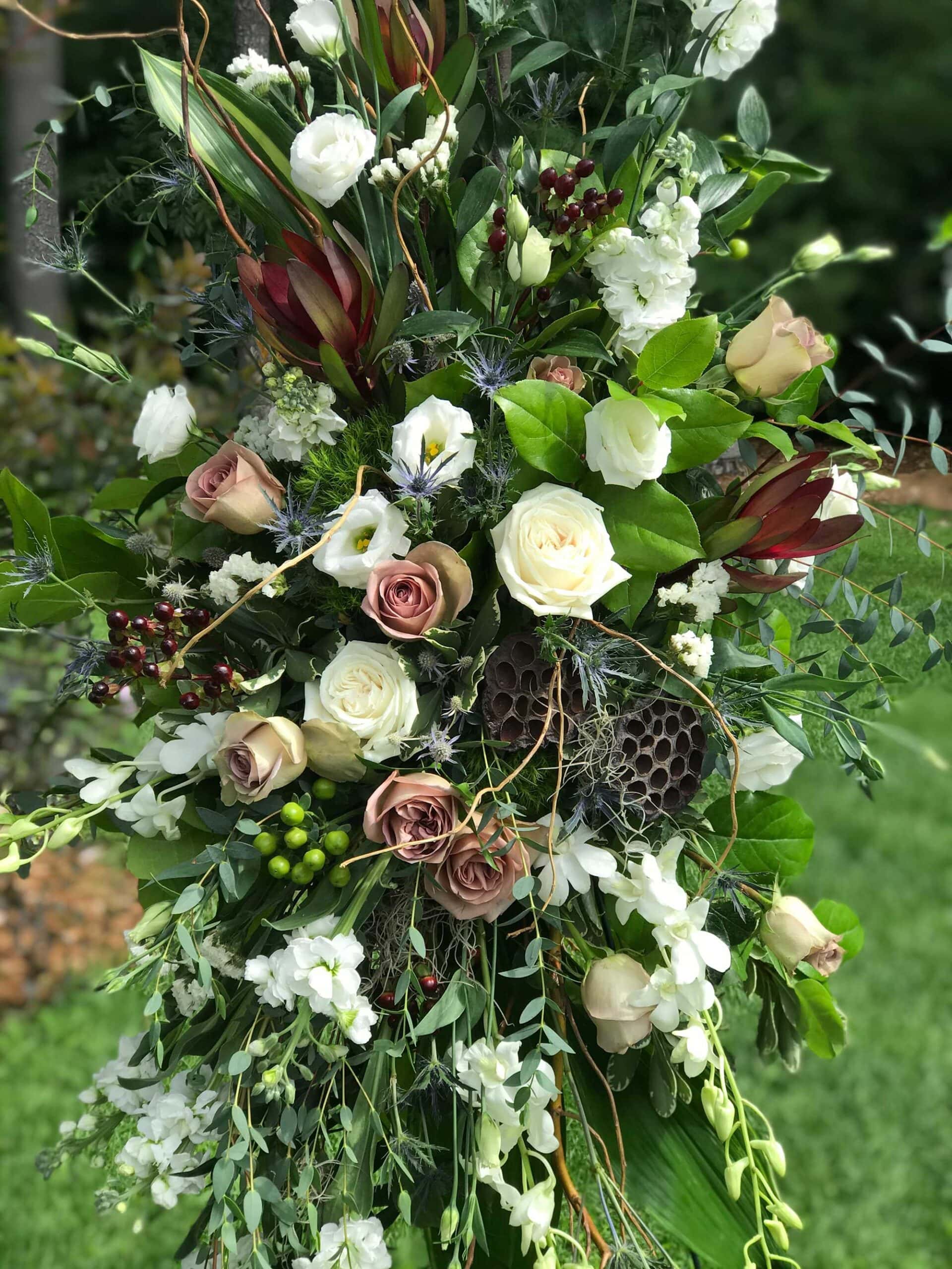 Sympathy arrangement Sympathy floral arrangement in roses, chrysanthemum, dried materials and more in burgundy, rust and white from Art in Bloom Floral Studio in Howell, Michigan.