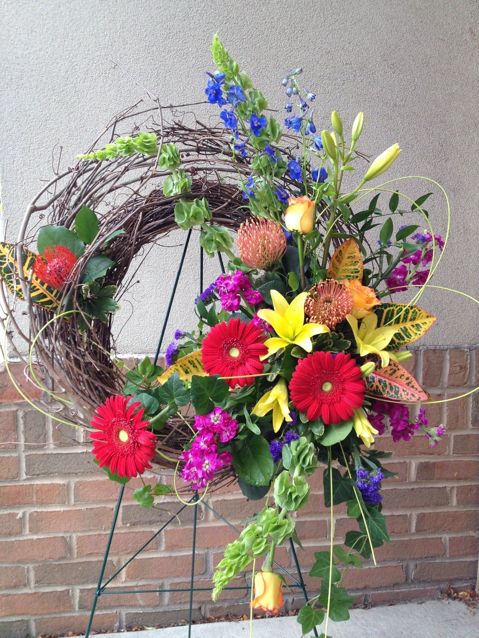 Large-Bright-Sympathy-Wreath A sympathy floral arrangement in a tall vase that includes hydrangea, snap dragons, roses and more from Art in Bloom Floral Studio in Howell, Michigan.