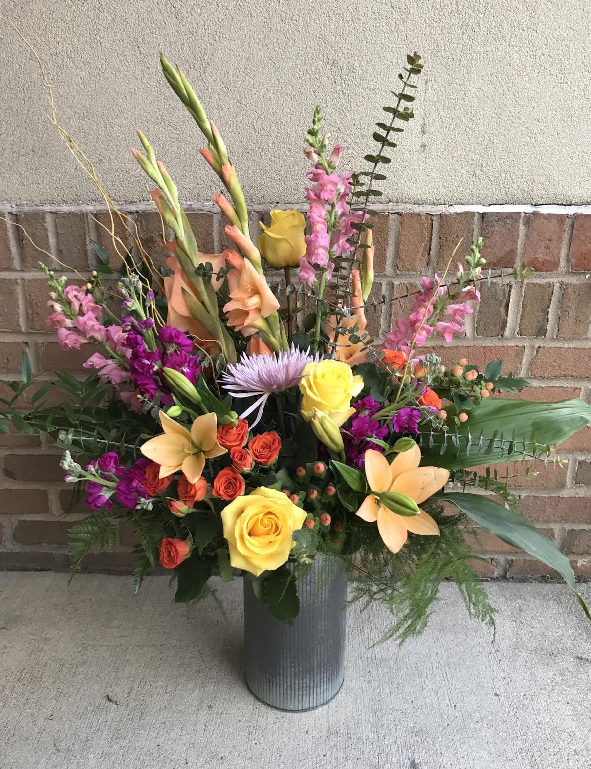 Yellows-Orange-Pinks-large-vase A floral arrangement from Art in Bloom Floral Studio in Howell, Michigan.