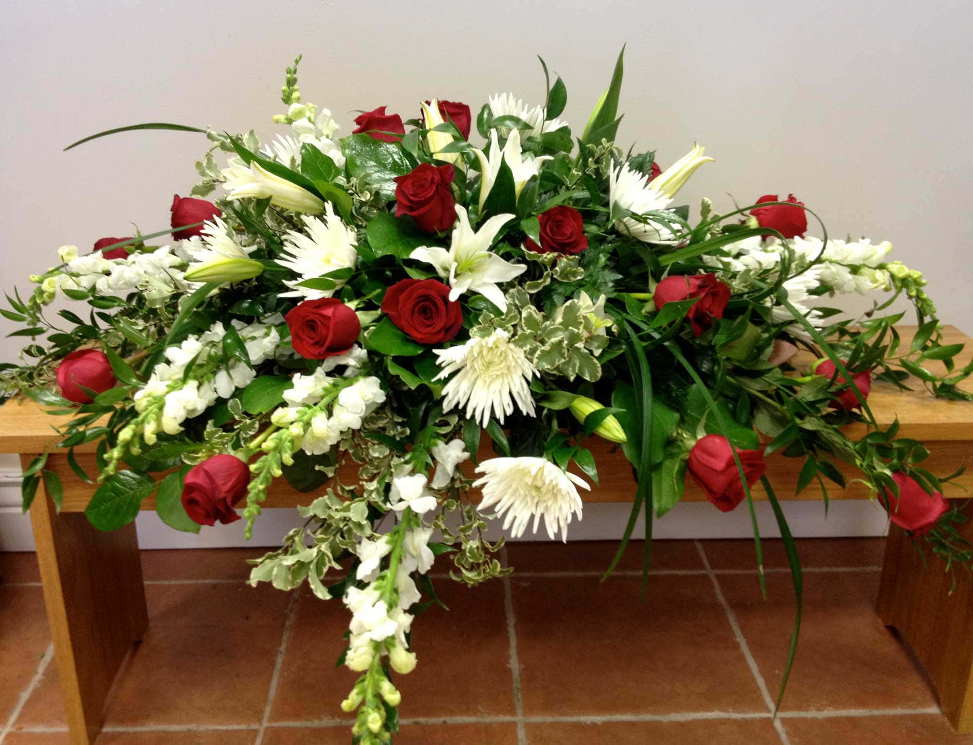 Red and White Casket Arrangement A casket spray floral arrangement from Art in Bloom Floral Studio in Howell, Michigan.